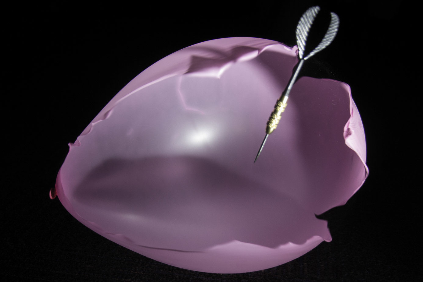 Throwing darts at balloons in a crowded room with lights off