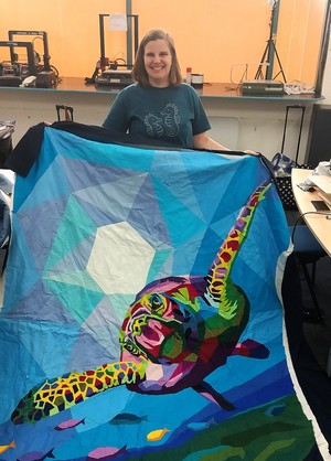 Member showing off patchwork quilt